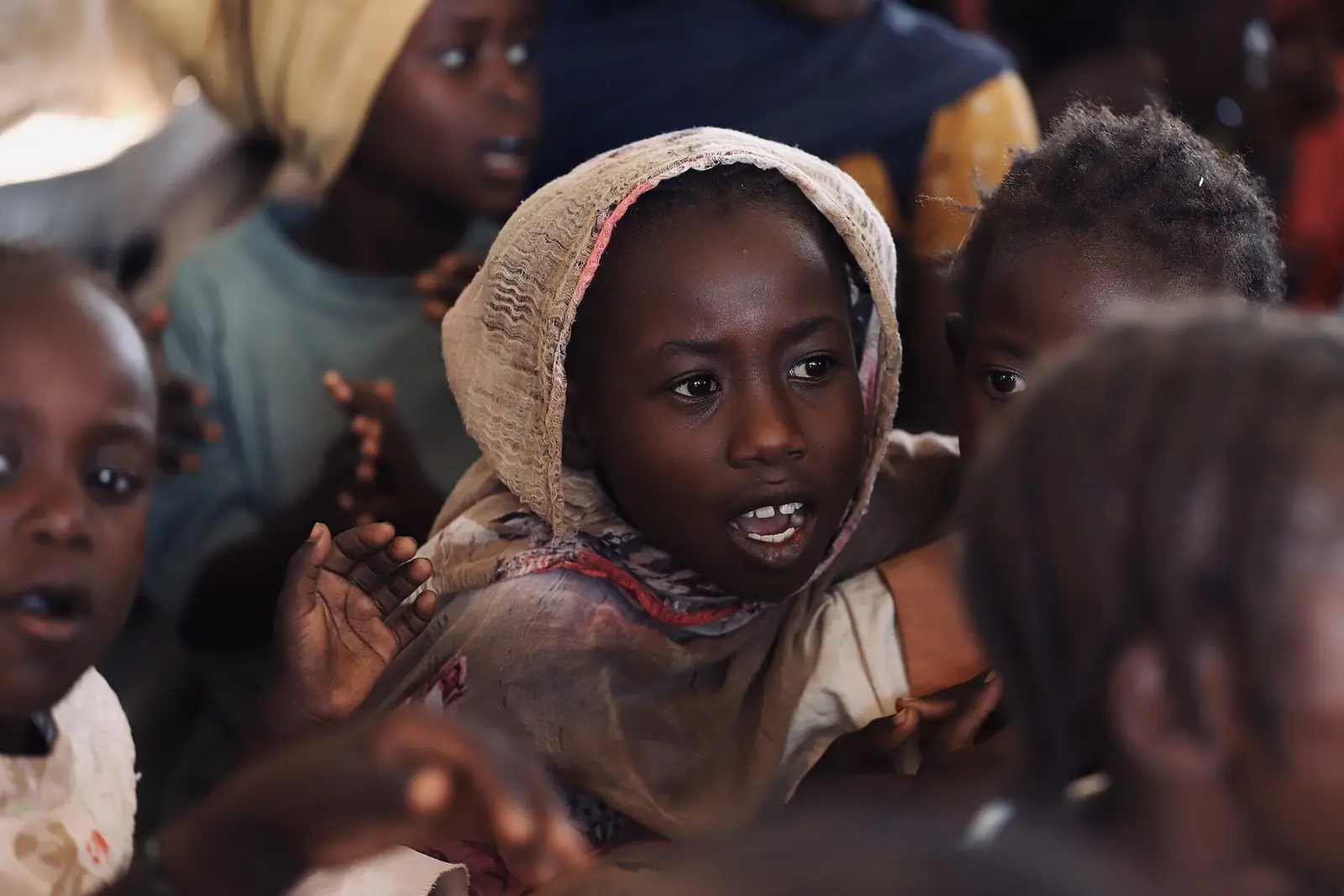 Aid convoy and shelter tents in an arid displacement site in Sudan