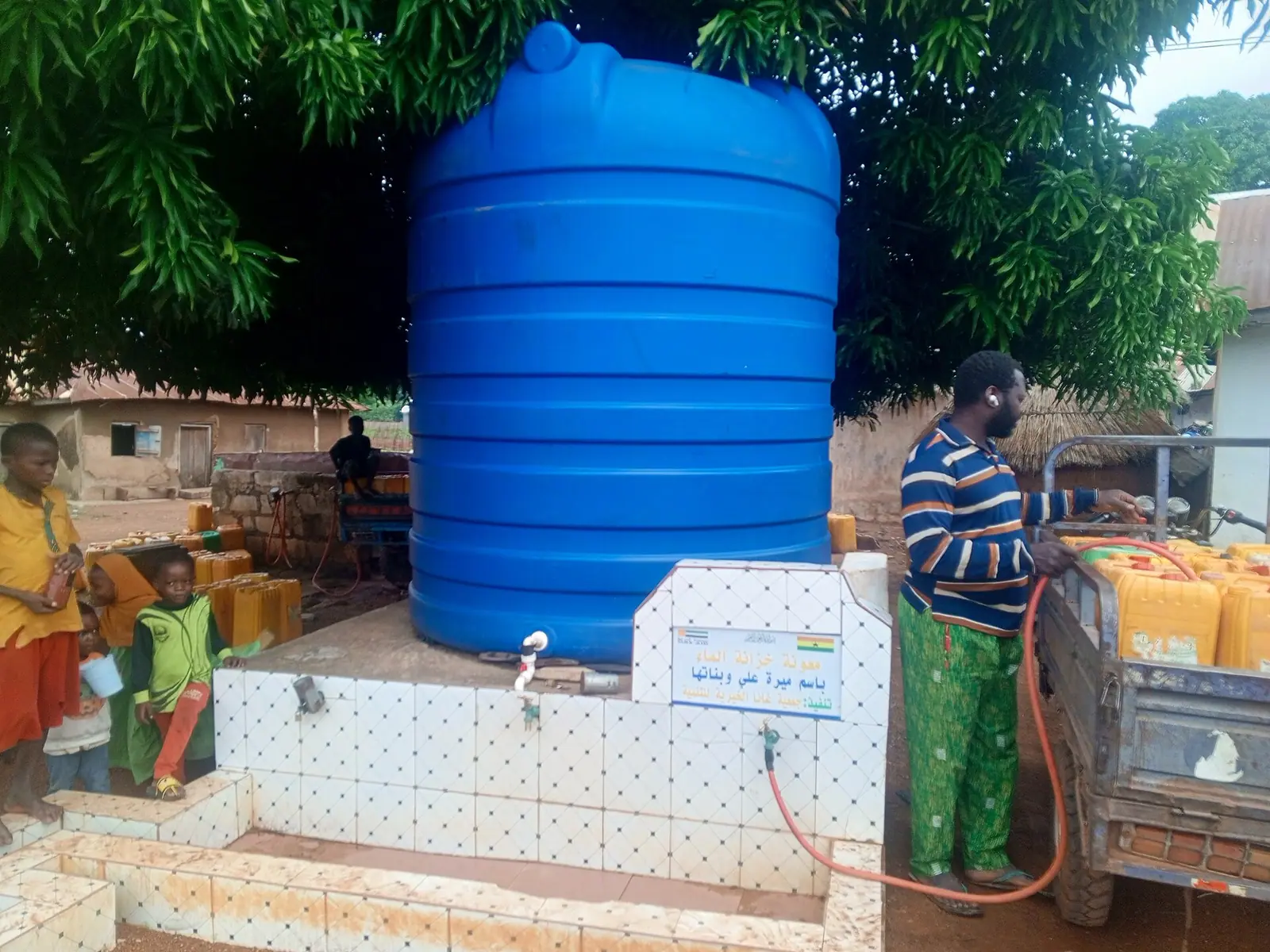 A mother and child collecting clean water at a village hand pump