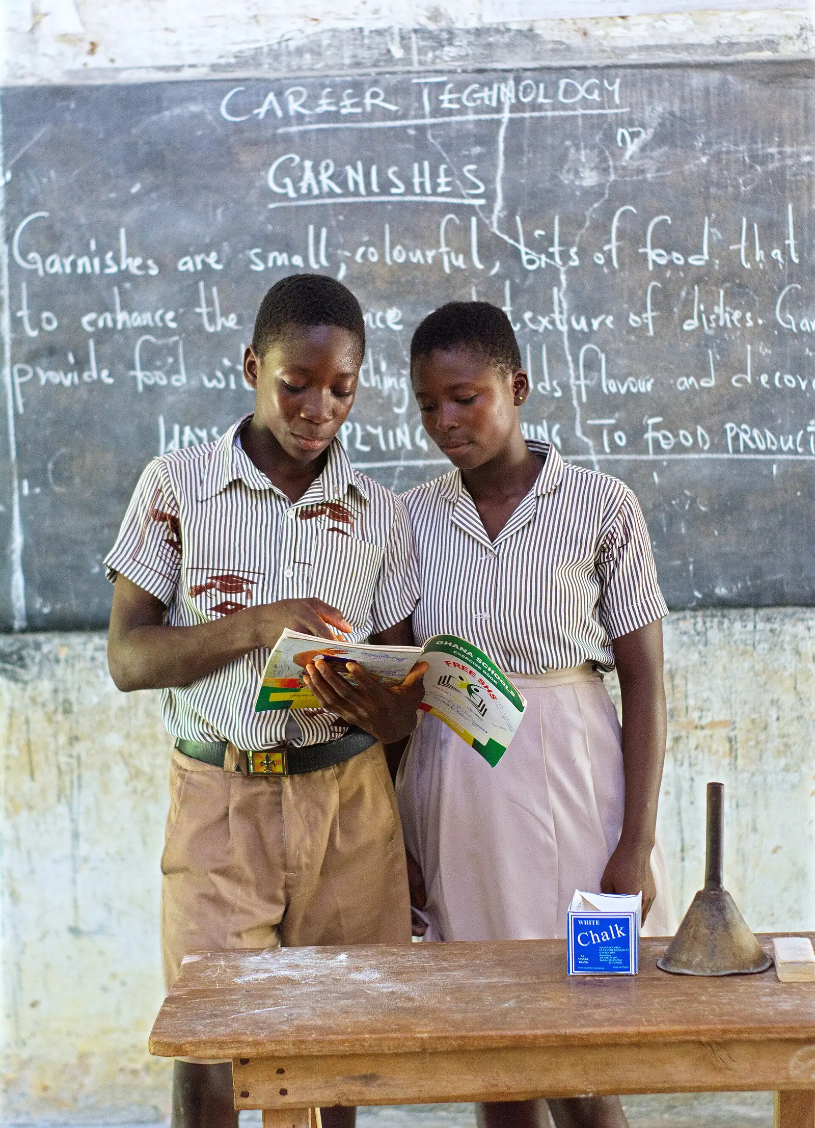 A teacher helping children with schoolwork in a classroom