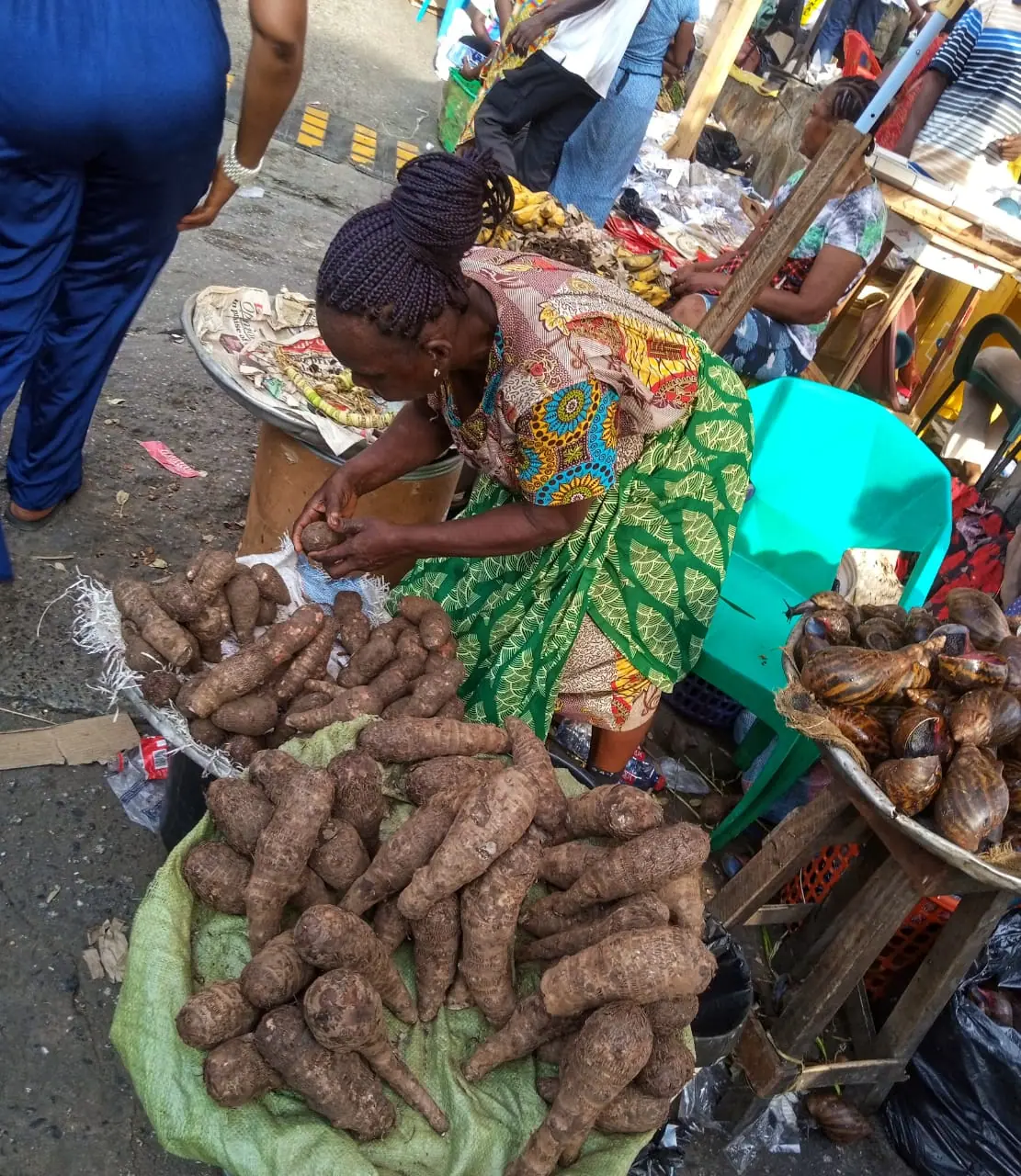 A busy woman selling cocoyam in the market