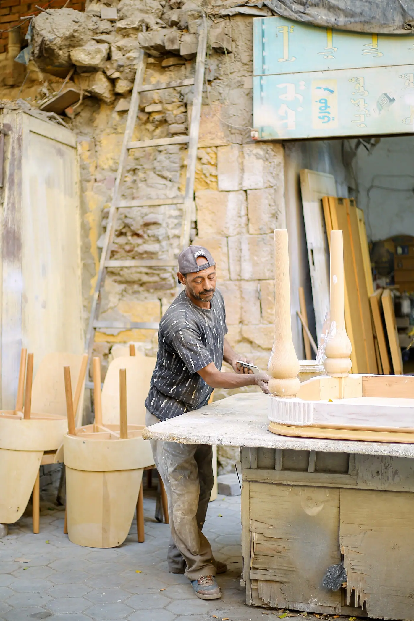 A documentary photograph showcasing the meticulous manual labor in Historic Cairo. It captures an artisan focused on cra